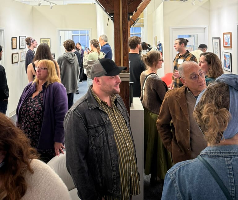 A packed opening reception with visitors mingling beneath gallery lights