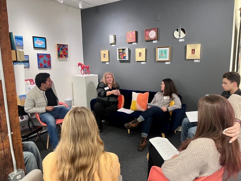 A panel discussion in a gallery, group of jurors talking and listening