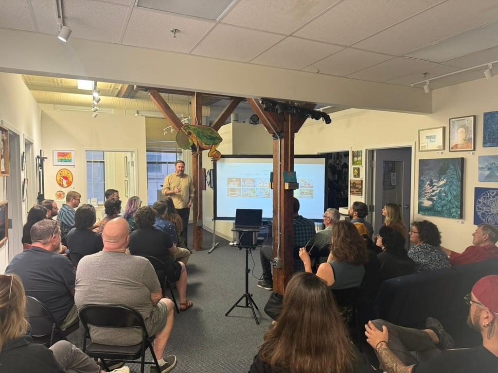 Speaker presenting to a seated audience inside a gallery space